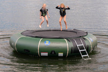 Two girls jumping on a Island Hopper 15' Classic Water Trampoline - 15'PVCTUBE Green with a black jumping mat and a white metal ladder.