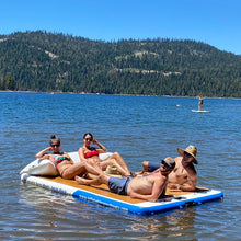 People lounging on Island Hopper Yacht Dock in a lake with a scenic background