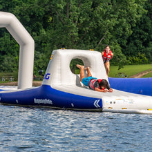 Inflatable water slide on a lake with people enjoying the activity