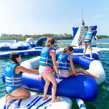 Children on an inflatable water park structure in a body of water with trees in the background.