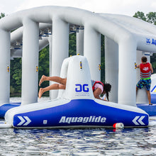Inflatable water park structure with 'Aquaglide' branding on a body of water.