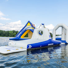 Inflatable water park on a lake with blue sky and clouds.