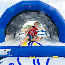 Child in a life jacket inside an inflatable water slide tunnel