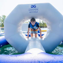 Child playing on an inflatable water toy with 'AG Universal Keyhole' branding in a lake.