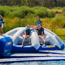 Children on an inflatable water toy in a pond with grassy background
