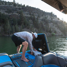 Person on a boat in a lake with a mountainous background