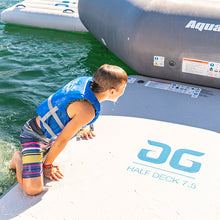 Child in a life jacket climbing onto an Aquaglide Half Deck 7.5 