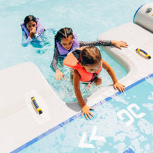 Children playing in a pool with inflatable toys and floaties.