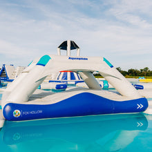 Inflatable water park structure with 'Aquaglide' and 'Fox Hollow' branding on a pool.