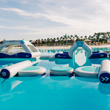 Inflatable water toys on a pool with palm trees in the background