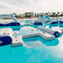 Inflatable pool toys floating on a pool with palm trees in the background