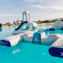 Inflatable water toys floating in a pool with clear blue water and a scenic background.