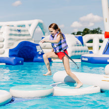 Girl in a life jacket on an inflatable water obstacle course