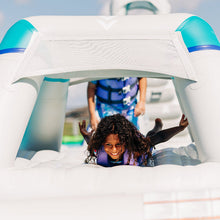 Child playing on a bouncy castle with another child in the background