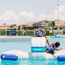 Two children playing on inflatable toys in a pool with 'Aquaglide' branding.