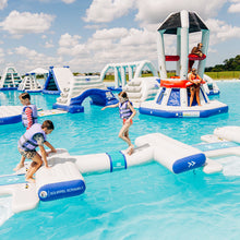 Children playing on inflatable water toys in a pool with a clear blue sky.