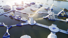 Model of a futuristic water park with various structures on a body of water.