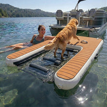 Woman and dog on Island Hopper Island Boarding Buddy in a lake with a pontoon boat in the background.