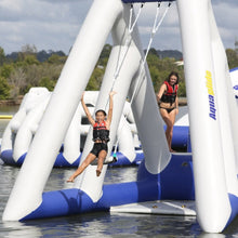 Two people on an inflatable water park structure with 'AquaGlide' branding on a body of water.
