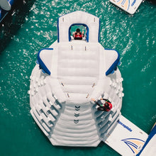 Inflatable water slide on a body of water with people at the top.
