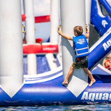 Child on an inflatable water obstacle course with 'Aquaglide' branding.