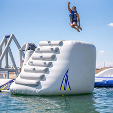 Person jumping off an inflatable water obstacle course into a body of water.