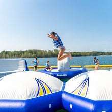 Person jumping off an inflatable water toy into a lake with clear blue sky.