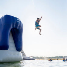 Person jumping off a large inflatable slide into water