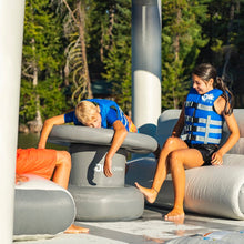Children playing on Ohana Lounge by a lake with trees in the background