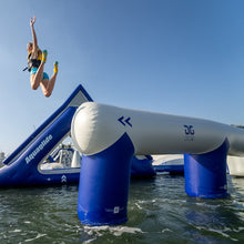 Person jumping off an inflatable water slide into a body of water with 'AquaGlide' branding.