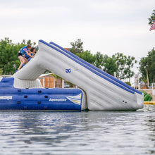 Inflatable water slide with 'Aqua glide' branding on a body of water.