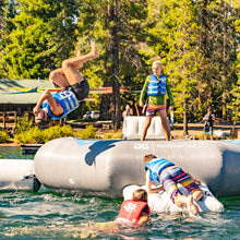Outdoor water park scene with multiple people using Aquaglide Ricochet Bouncer 12.0 Aquapark