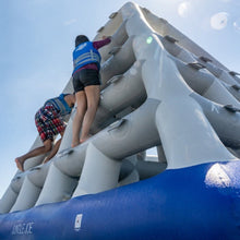 Children climbing on an inflatable playground structure with a clear blue sky.