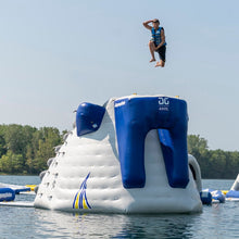 Person jumping off an inflatable water structure into a lake