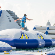 Person on an inflatable water obstacle course with blue and white colors.