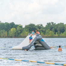 Inflatable water slide on a lake with people enjoying the activity
