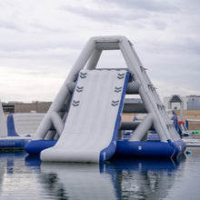 Inflatable water slide structure on water with a cloudy sky background
