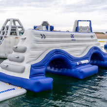 Inflatable water park structure floating on water with cloudy sky in the background