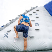 Person climbing an inflatable water obstacle course