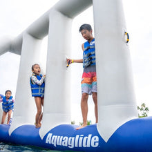 Children playing on an inflatable water toy with 'Aquaglide' branding.