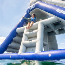 Person on an inflatable water slide with 'Aquaglide' branding