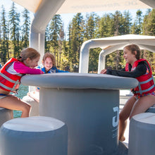 Three children in life vests sitting around Aquaglide OG Lounge 
