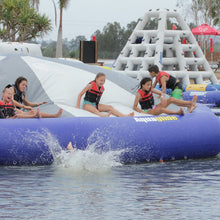 Children playing on an inflatable water slide at a water park.