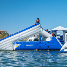 Inflatable water slide and platform in a body of water with clear blue sky.