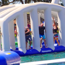 People playing on an inflatable water obstacle course in a pool