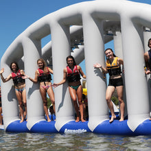 Group of people on an inflatable water slide with 'AquaGlide' branding.