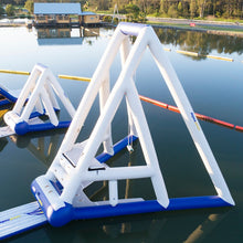 Inflatable water slide on a lake with a dock and trees in the background