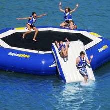 People enjoying an inflatable water trampoline in the water with 'Aquaglide' branding.