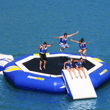 People on an inflatable water trampoline in the water with 'AquaGlide' branding.