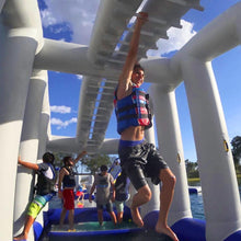 Person on an inflatable water slide with a blue sky and clouds in the background